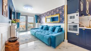 a blue couch in a living room with blue walls at Apartamenty Sun & Snow Balticus in Międzyzdroje