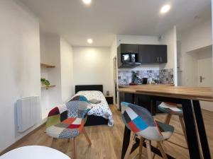 uma cozinha com uma mesa, 2 cadeiras e uma secretária em Le Montgy - Studio tout confort à Royat National N1 em Royat