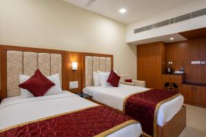 a hotel room with two beds with red pillows at HOTEL BLUEMOON in Tirunelveli +119 photos