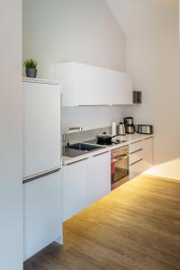 una cocina con armarios blancos y fregadero en Ferienhaus Stilloft One en Wernigerode