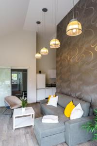 ein Wohnzimmer mit einem grauen Sofa und gelben Kissen in der Unterkunft Ferienhaus Stilloft One in Wernigerode