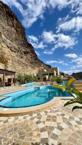 a swimming pool in front of a mountain at Tilal Al-Qattara in Mashūq