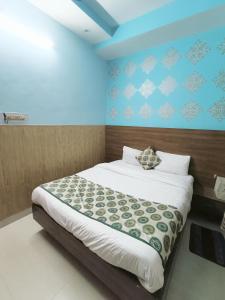 a bedroom with a bed and a blue wall at Hotel Atithi Residency in Lucknow
