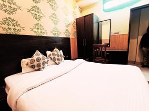 a bedroom with a bed with white sheets and pillows at Hotel Atithi Residency in Lucknow