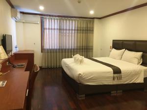 a hotel room with a bed and a desk at Nakhone Champa Hotel in Pakse