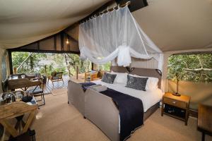 a bedroom with a bed in a tent at Tsowa Safari Island in Victoria Falls