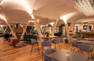 Un restaurante con mesas y sillas en una sala. en Hotel Garberhof, en Malles Venosta