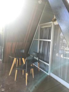 mesa y sillas en una habitación con ventana en Orkid Chalet en Cameron Highlands