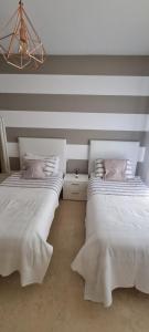 - 2 lits dans une chambre aux murs rayés dans l'établissement Capanes del golf, à Benahavís