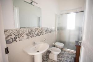 a white bathroom with a sink and a toilet at Villa Rebecca in Porto Cesareo