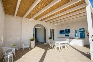 a patio with a table and chairs and a kitchen at Villa Rebecca in Porto Cesareo