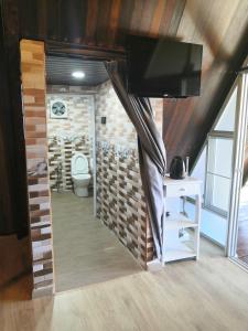 金馬崙高原的住宿－Orkid Chalet，一间带卫生间的浴室和客房内的电视。