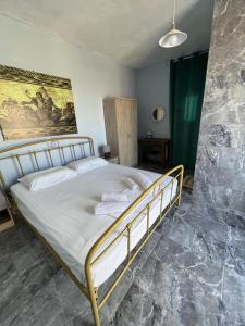 een slaapkamer met een bed en een schilderij aan de muur bij Villa Hellas in Afiartis