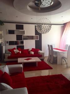 een woonkamer met een rode bank en een tafel bij Belle appartement 3 pièces à 500m de la plage in Nabeul