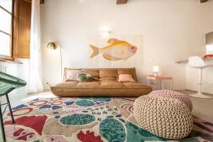 a living room with a couch and a fish painting on the wall at La Corticella Luxury Suite, with Terrace in Lucca