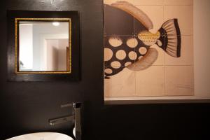 a mirror in a bathroom with a fish on the wall at La Corticella Luxury Suite, with Terrace in Lucca +33 photos