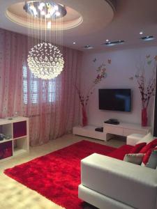 een woonkamer met een witte bank en een rood tapijt bij Belle appartement 3 pièces à 500m de la plage in Nabeul