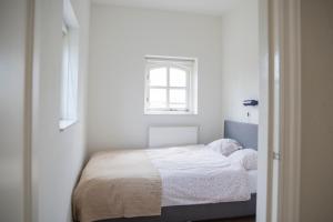 een kleine slaapkamer met een bed en een raam bij De Dorsvloer in Drimmelen