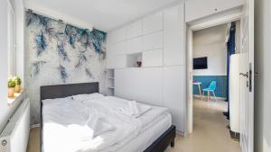 a bedroom with a bed and a blue and white wall at Apartamenty Sun & Snow Mare Promenada in Międzyzdroje