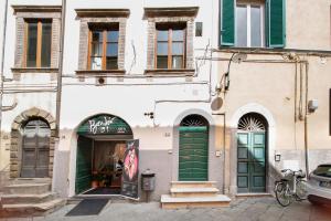 a building with green doors on a street at La Corticella Luxury Suite, with Terrace in Lucca