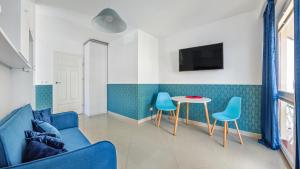 a living room with a blue couch and a table at Apartamenty Sun & Snow Mare Promenada in Międzyzdroje