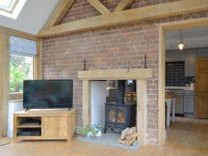 a living room with a brick wall and a fireplace at Wayside House - UK32090 in Broome
