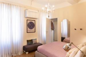 sypialnia z łóżkiem, krzesłem i żyrandolem w obiekcie Casa delle Stelle Luxury w Lukce