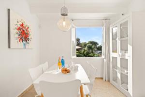 a white dining room with a white table and a window at Villa San Cristobal by 3VILLAS in Binibeca