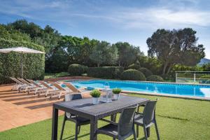 a table and chairs next to a swimming pool at Villa San Cristobal by 3VILLAS in Binibeca +30 photos