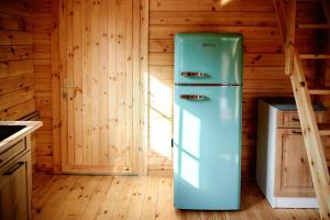 - un réfrigérateur dans la cuisine d'une cabine dans l'établissement SŁODKA WODA NIEBIESKI Domek, à Lubieszewo