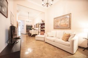 ein Wohnzimmer mit einem weißen Sofa und einem TV in der Unterkunft Re Migio Apartment with Terrace and Lift in Lucca