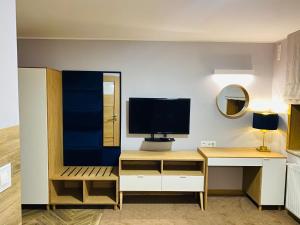 a room with a desk with a computer and a television at Hotel Kosmowski in Września