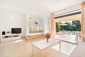 a living room with a tv and a table at Villa San Cristobal by 3VILLAS in Binibeca