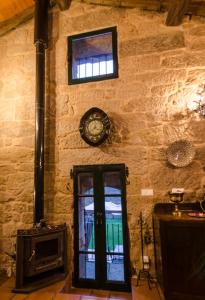 uma parede de tijolos com uma porta e um relógio na parede em A casa da Ita em Ourense