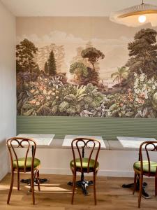 a large painting on a wall with two chairs and a table at Hotel Saint Louis in Brest