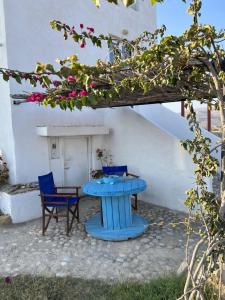 een blauwe tafel en stoelen voor een gebouw bij Villa Hellas in Afiartis
