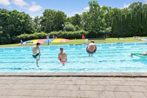 - un groupe de personnes se baignant dans une piscine dans l'établissement First Camp Röstånga-Söderåsen, à Röstånga