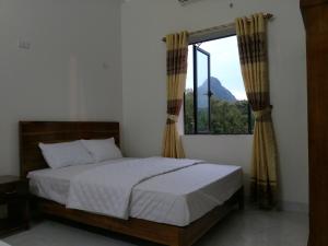 a bedroom with a bed and a large window at Tuyet's hostel in Ninh Binh