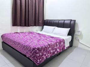 een bed in een kamer met een paarse deken bij Feel Homestay in Cameron Highlands +17 foto's
