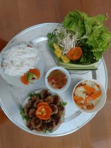 a table with plates of food and a salad at Tuyet's hostel in Ninh Binh