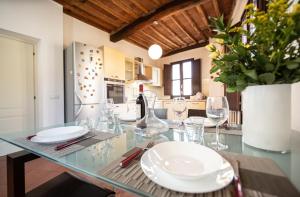 a dining room with a glass table with wine glasses at Serena Apartment, Cosy Close Center Town in Lucca
