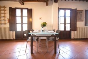 a dining room with a table and chairs and windows at Serena Apartment, Cosy Close Center Town in Lucca