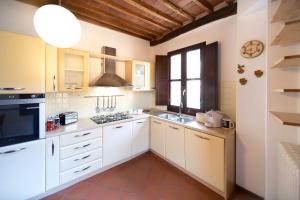 a kitchen with white cabinets and a large window at Serena Apartment, Cosy Close Center Town in Lucca +46 photos