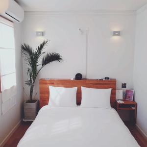 a bedroom with a large white bed with two pillows at That space Jeju in Jeju