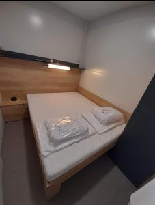 un piccolo letto in una piccola camera di M&M Mobile home a Privlaka (Brevilacqua)