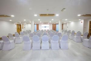 HAFFA HOUSE HOTEL في مسقط: غرفة فارغة مع كراسي بيضاء في غرفة
