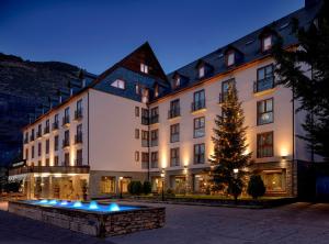 a large building with a christmas tree in front of it at Hotel Vielha Val d'Aran, Affiliated by Meliá in Vielha