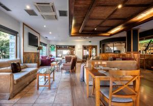 un restaurante con sofás, mesas y sillas en Hotel Vielha Baqueira, Affiliated by Meliá, en Vielha