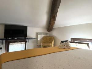 a bedroom with a bed with a tv and a chair at Poste Regie - Milan Guest House in Milan