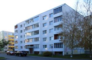 a white building with cars parked in front of it at Cozy 2-room studio in Tallinn